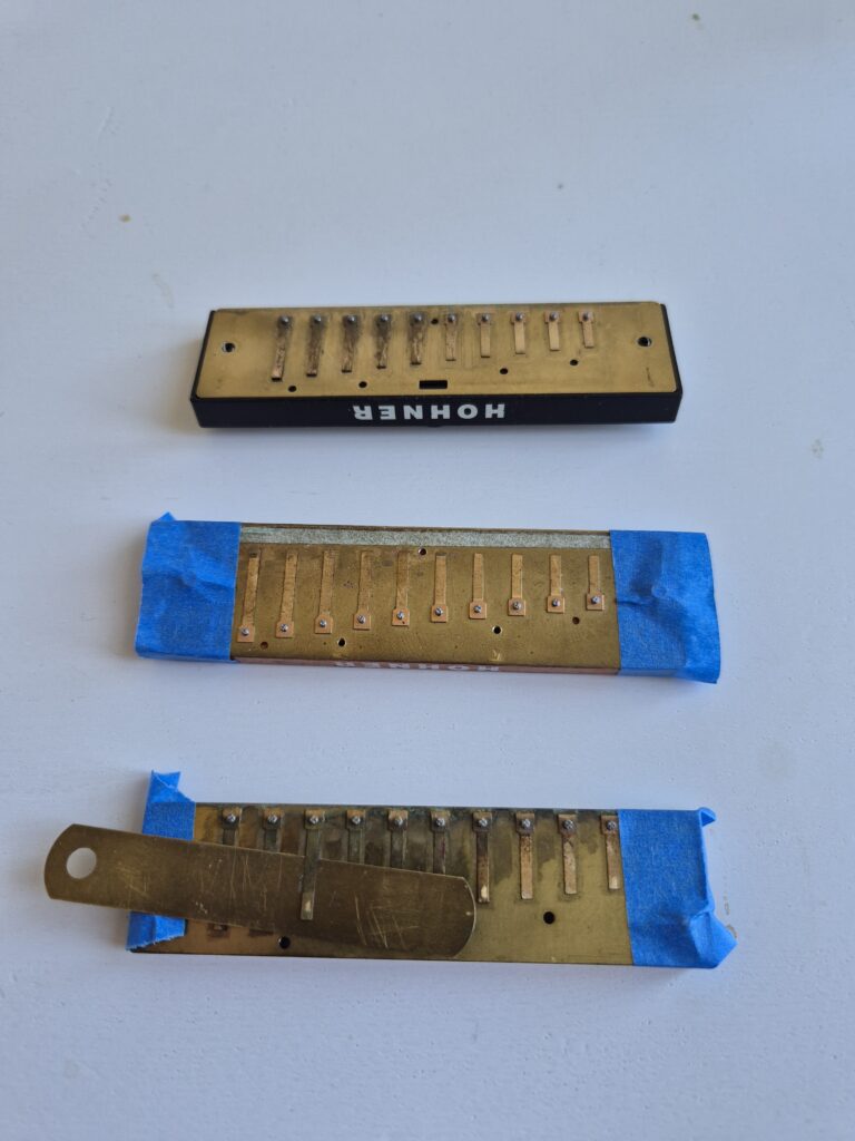 Three different combs with exposed reeds on plates on the lower (draw) side